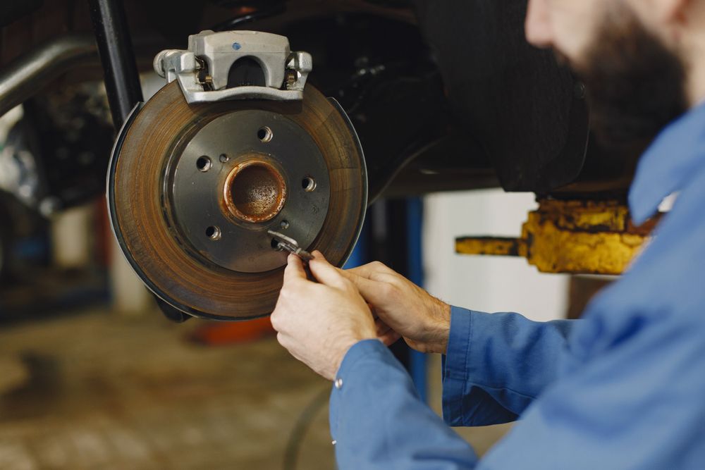 Hands inspecting a brake rotor during automotive service